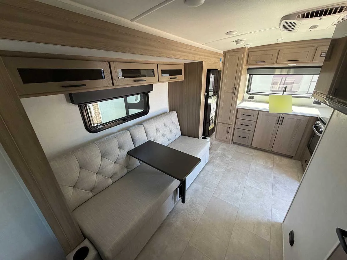 72-inch tufted sofa with table in the slide-out of the Rockwood Geo Pro G20SFK, with overhead cabinets