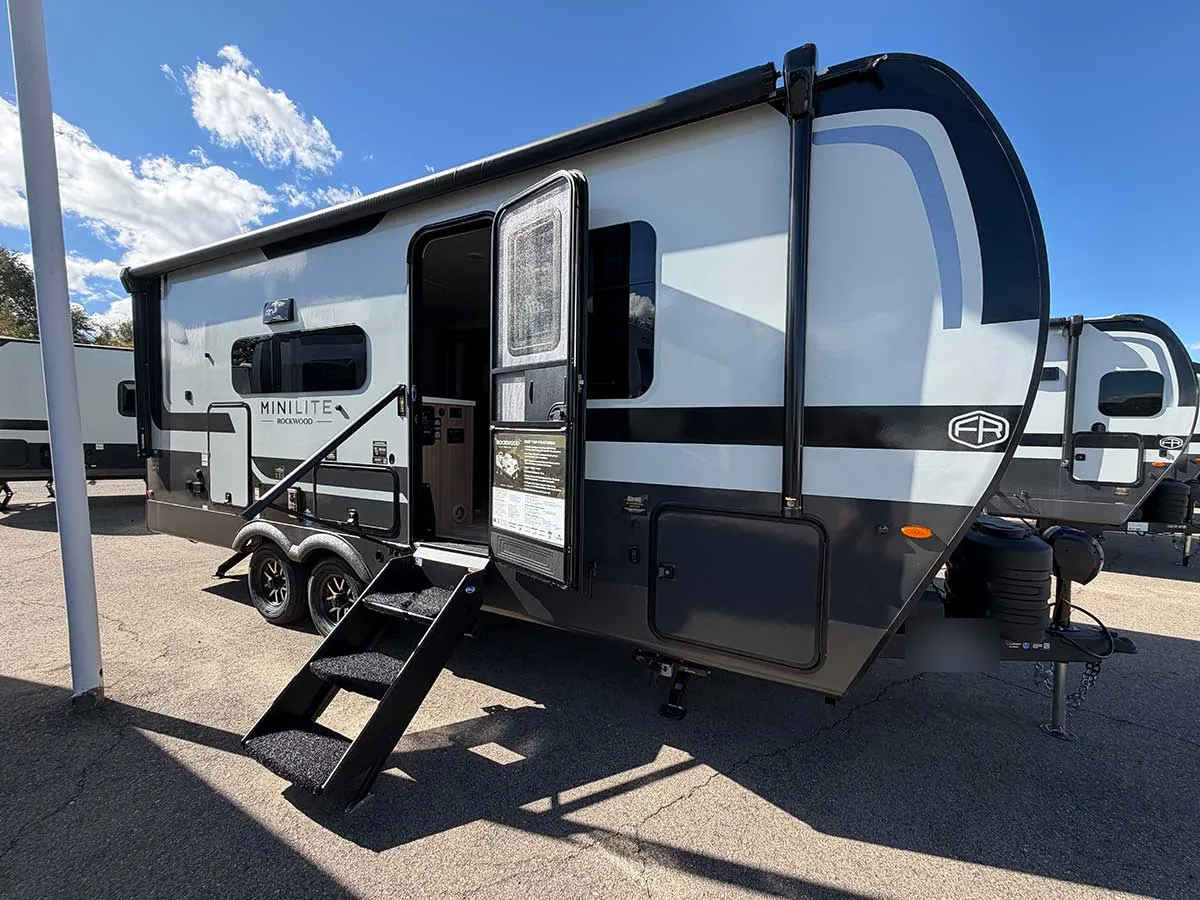 2213S door side with entry steps down, power awning rolled up and front storage door