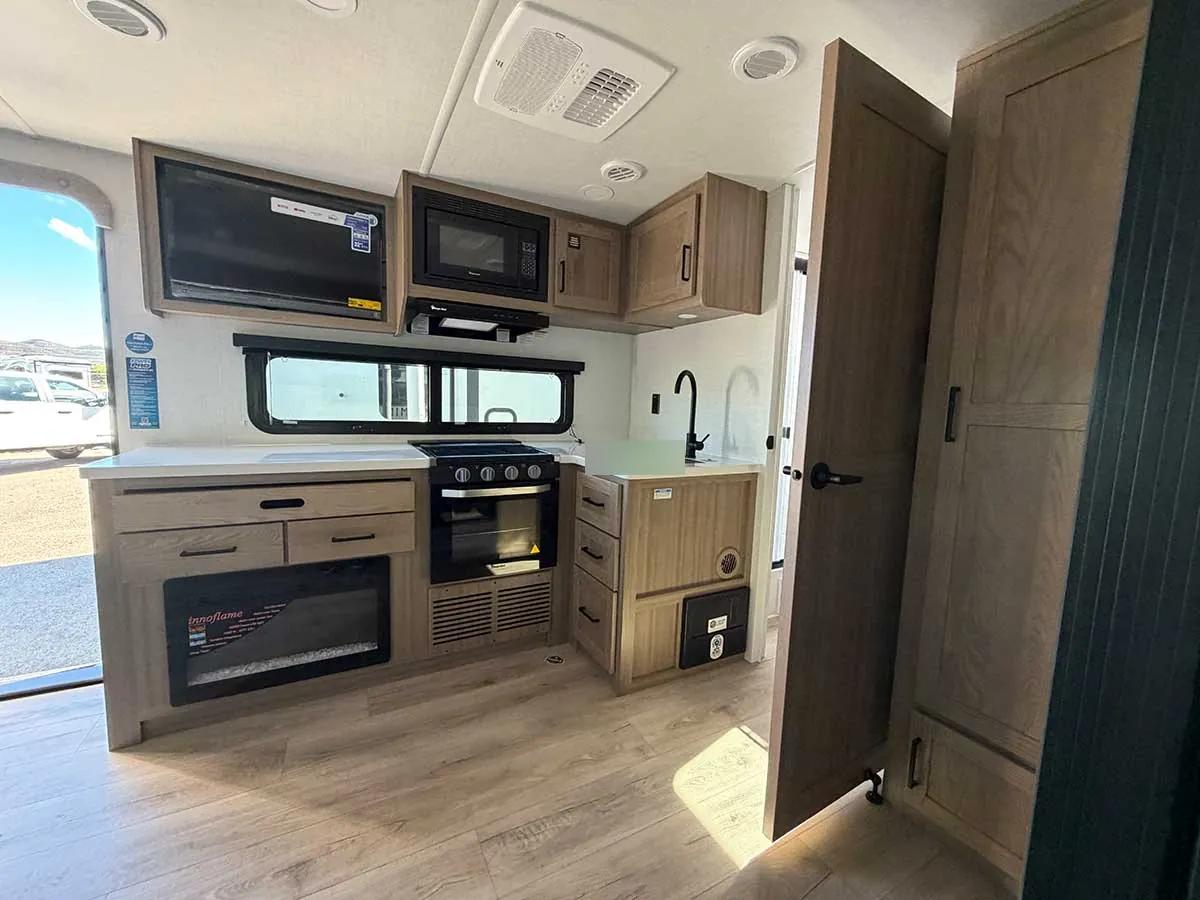 2213S kitchen with three-burner range and oven, microwave, TV, corner sink and electric fireplace