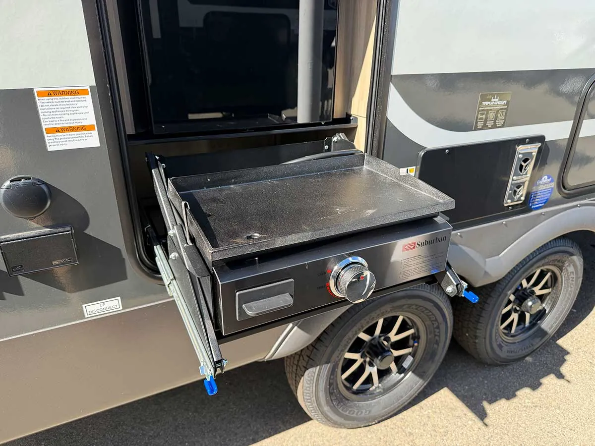 Suburban outdoor griddle pulled out of the side of the 2213S on a slide-out tray