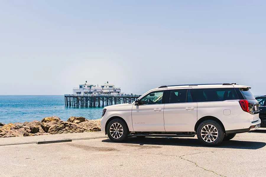 White Ford Expedition Platinum parked by the ocean